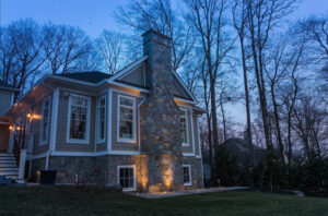 aqua-bright exterior lighting illuminating the foundation of a house in early evening